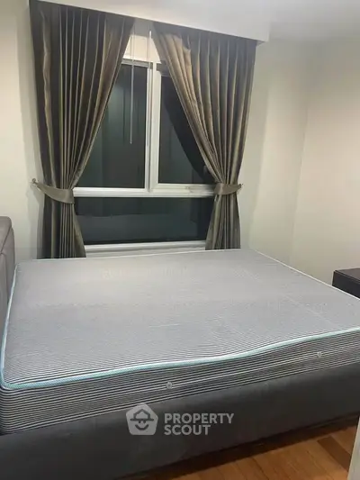 Cozy bedroom with elegant curtains and a comfortable bed, perfect for restful nights.