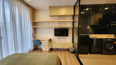 Modern studio apartment with sleek kitchen and cozy workspace