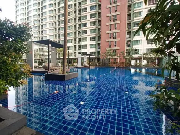 Luxurious condominium pool with modern design and lush greenery
