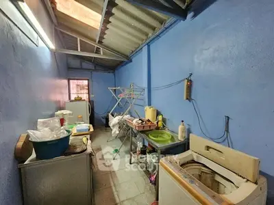Functional utility room with washing machine and storage space in a blue-painted interior.