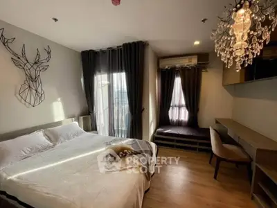 Modern bedroom with elegant chandelier and cozy decor, featuring a large window with curtains and stylish furnishings.