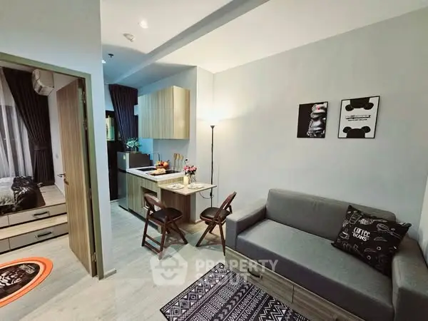 Modern open-plan living room with cozy decor and compact kitchen area.