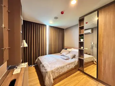 Modern bedroom with wooden flooring, cozy bed, and mirrored wardrobe in a stylish apartment.