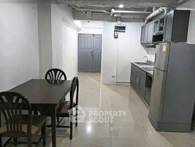 Spacious kitchen with dining area and modern appliances in a sleek apartment.
