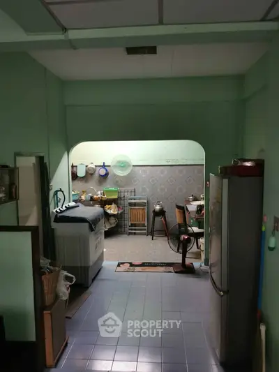Cozy kitchen with washing machine and dining area in a compact layout, perfect for efficient living.