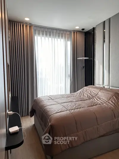 Modern bedroom with elegant decor and large window for natural light