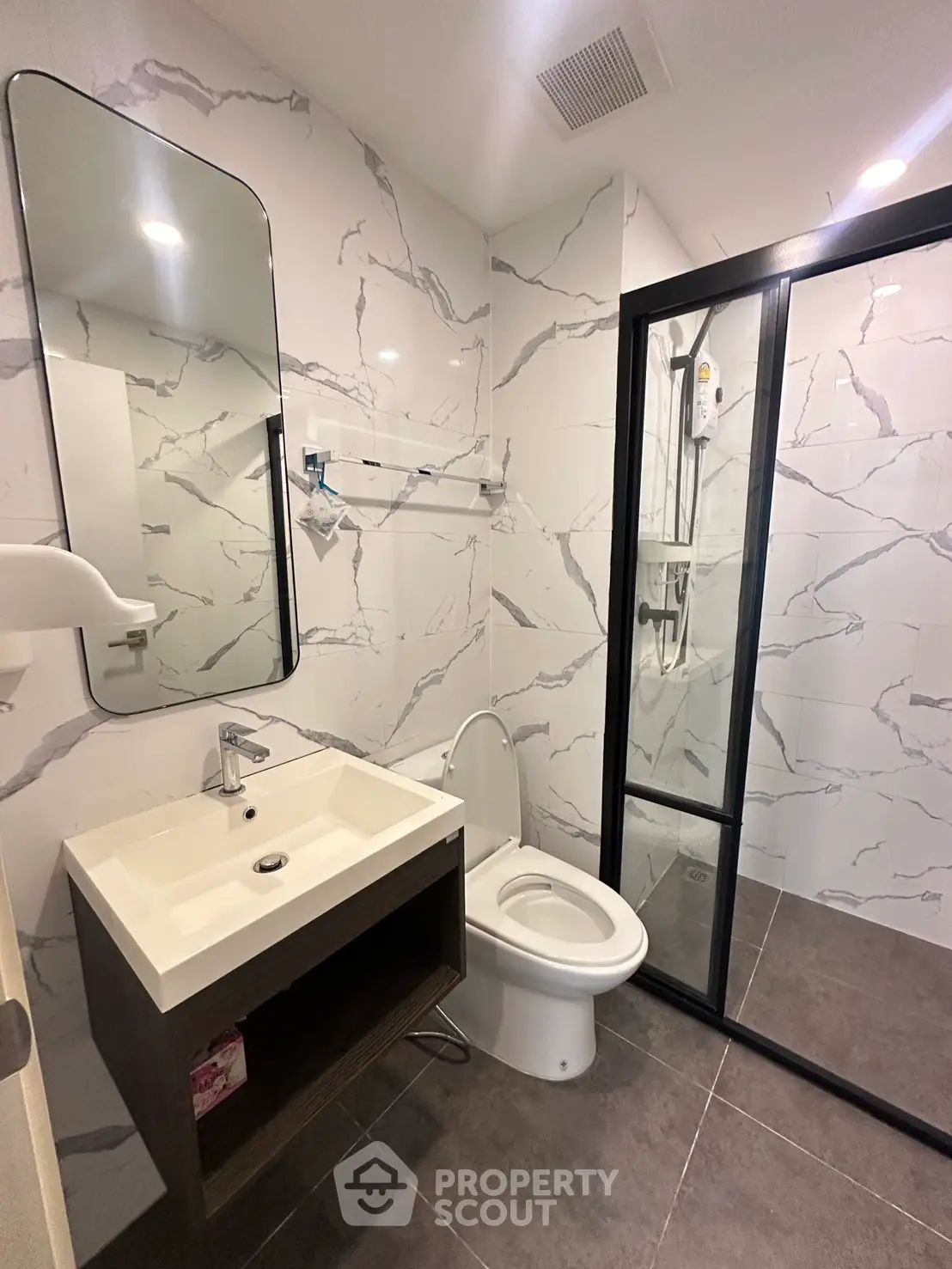 Modern bathroom with marble tiles and glass shower enclosure