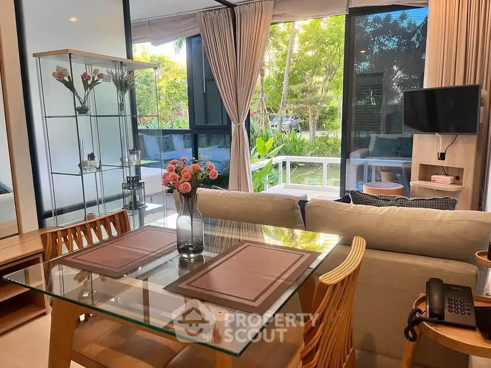 Charming living room with garden view, glass dining table, and cozy seating area.