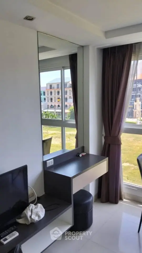 Modern living room with large window and sleek furniture in a stylish apartment.