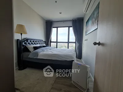 Modern bedroom with large window offering city view, featuring stylish bed and air purifier.