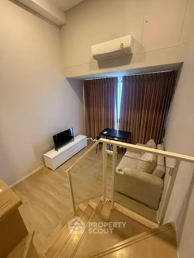 Modern loft-style living room with air conditioning and natural light