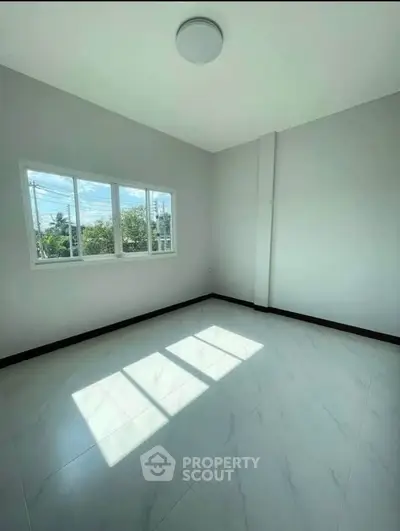 Bright empty room with large window and glossy tiled floor, perfect for customization.