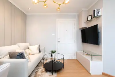 Stylish modern living room with cozy sofa, sleek TV setup, and elegant lighting.