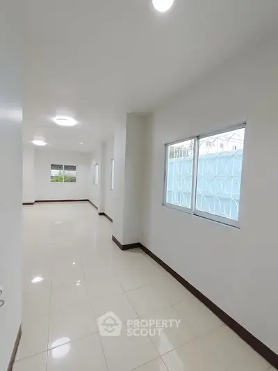 Spacious and bright interior with large windows and glossy tiled floor