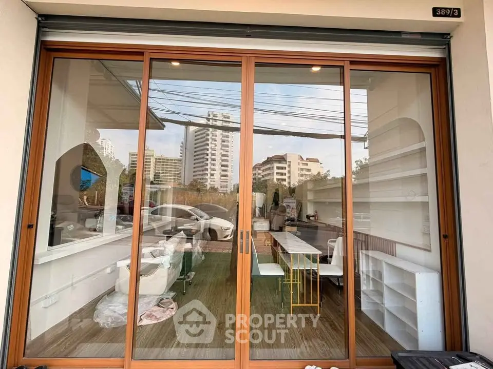 Modern commercial space with large glass doors and urban view, ideal for retail or office use.