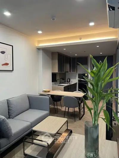 Modern living room with open kitchen, stylish furniture, and elegant decor