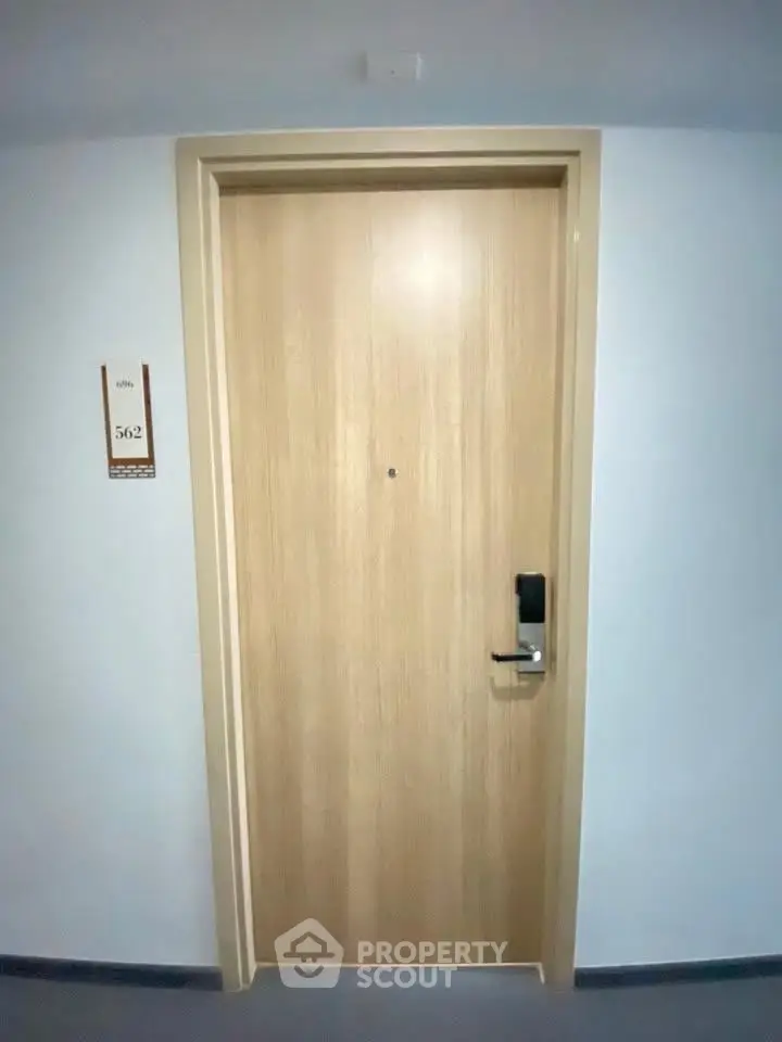 Modern apartment door with electronic lock and room number, ideal for secure urban living.