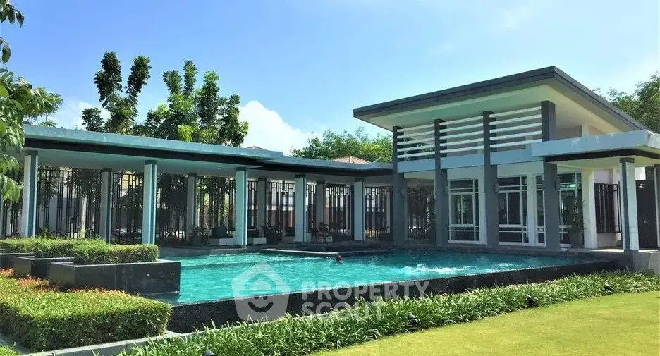 Luxurious modern home with stunning pool and lush garden, perfect for relaxation and entertainment.