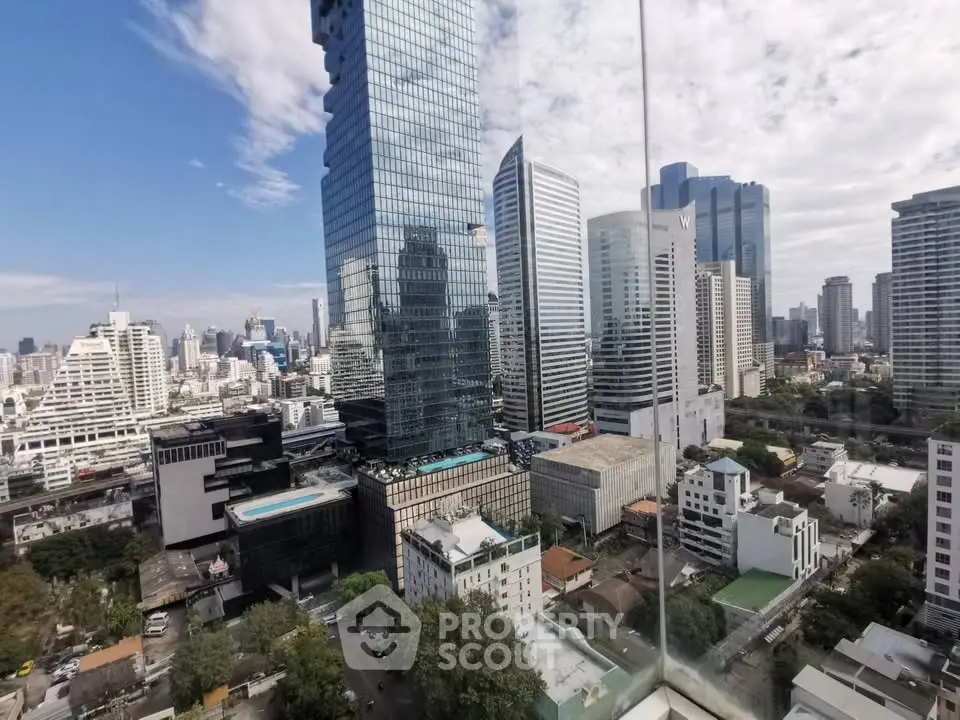 Stunning cityscape view from high-rise building with modern architecture and clear blue sky.