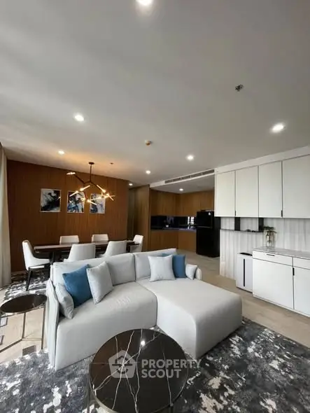 Modern open-plan living room with stylish furniture and elegant kitchen area