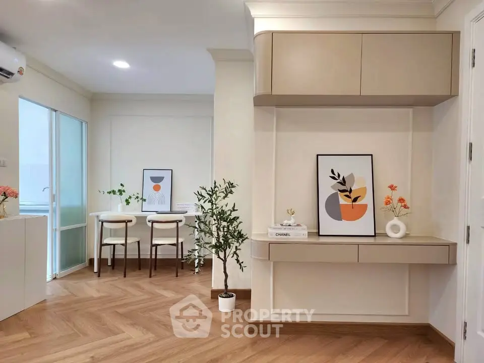 Modern living room with stylish decor and wooden flooring, featuring a cozy dining area and elegant wall art.