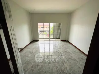 Spacious empty room with glossy marble flooring and balcony access