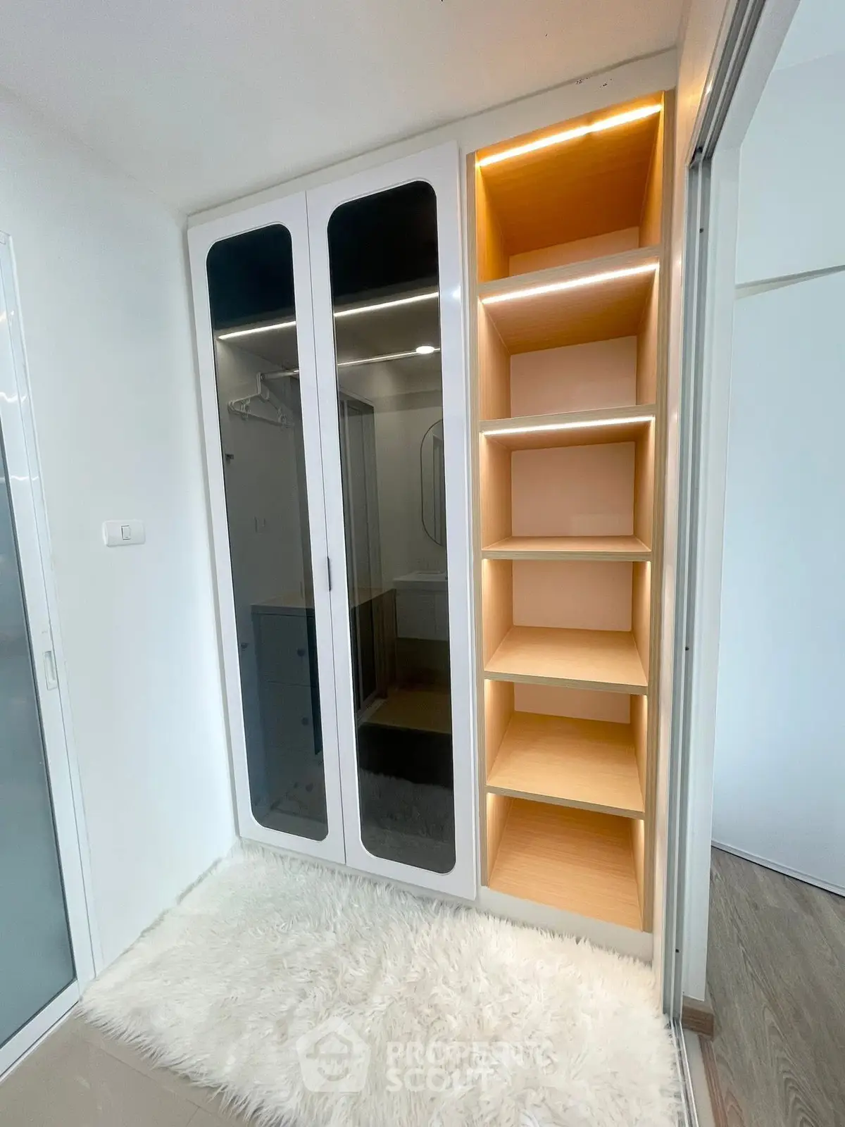 Modern closet with mirrored doors and illuminated shelves in a stylish interior