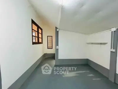 Spacious storage room with window and shelf, ideal for organizing and maximizing space efficiency.