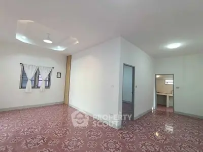 Spacious living room with unique patterned flooring and modern lighting