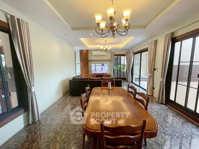 Spacious dining and living area with elegant lighting and large windows