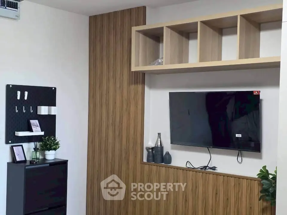 Modern living room with wall-mounted TV and stylish wooden shelving