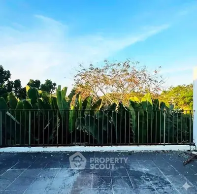 Spacious balcony with lush greenery and clear blue sky view