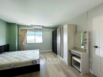 Spacious bedroom with large window and modern furnishings