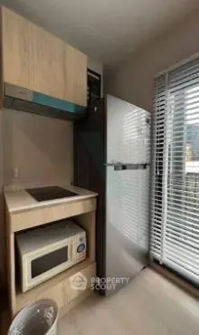Compact kitchen with modern appliances and large window for natural light.