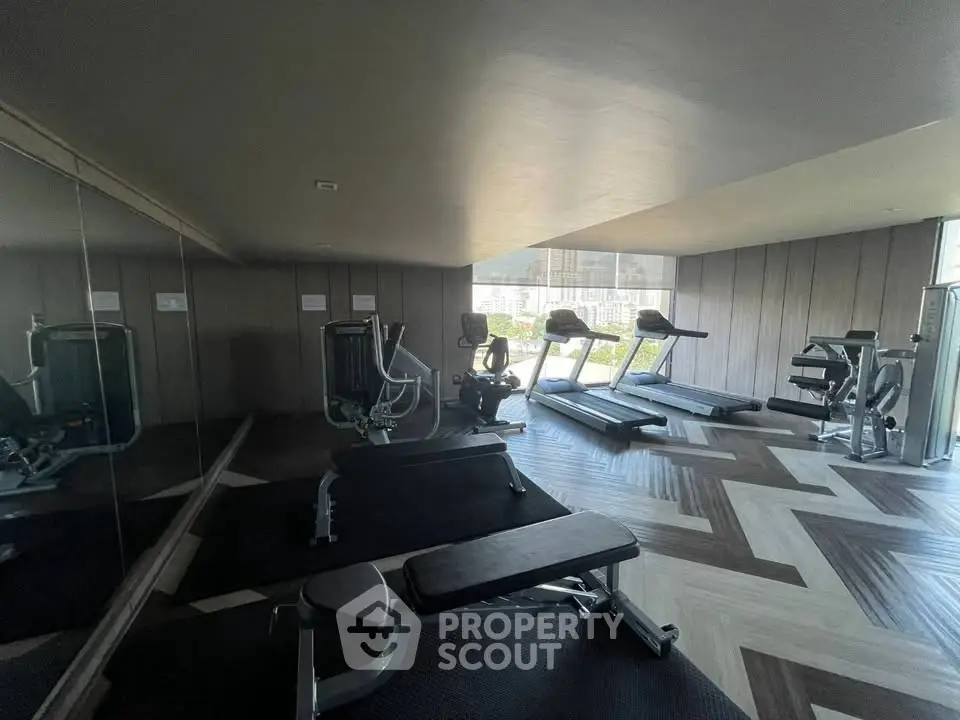 Modern gym with state-of-the-art equipment and large windows offering a scenic view.