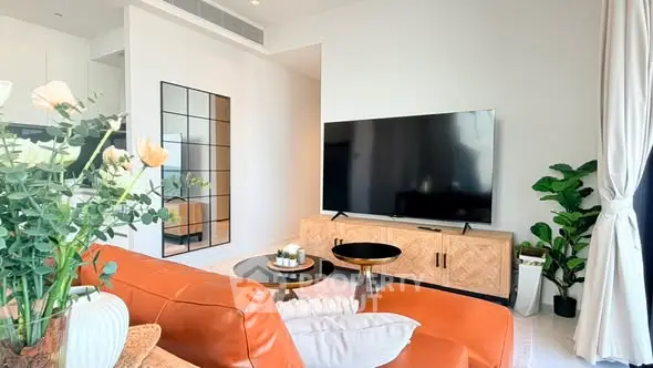 Luxurious modern living room with stylish decor and large TV, perfect for relaxation and entertainment.