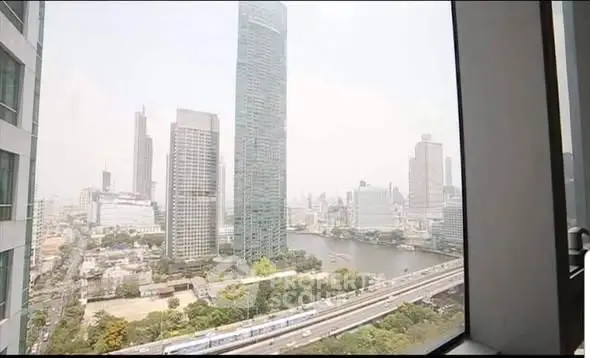 Stunning cityscape view from high-rise apartment window overlooking river and skyline.