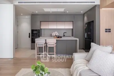 Modern open-layout kitchen with sleek cabinetry and cozy living area, perfect for contemporary living.