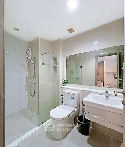 Modern bathroom with glass shower and sleek fixtures in a contemporary apartment.