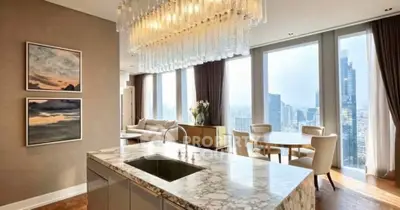 Luxurious open-plan kitchen and living area with stunning city views and elegant chandelier.