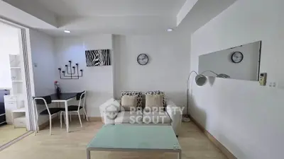 Modern living room with stylish decor and open layout, featuring a cozy sofa and glass coffee table.