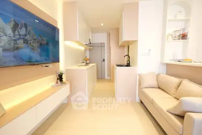 Modern living room with sleek design, featuring a large wall-mounted TV, cozy sofa, and stylish kitchen area.