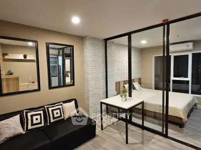 Modern studio apartment with glass partition, stylish decor, and cozy ambiance.