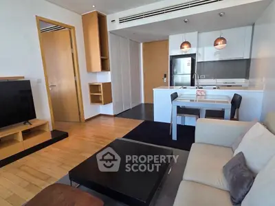 Modern living room with open kitchen, stylish decor, and cozy seating area in a contemporary apartment.