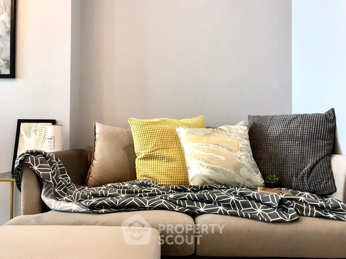 Cozy living room with stylish sofa and decorative cushions, perfect for relaxation.
