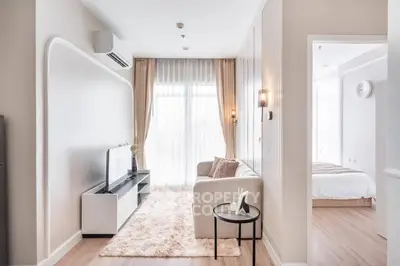 Modern living room with cozy sofa, TV, and elegant decor in bright apartment