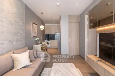 Modern living room with open kitchen, stylish decor, and cozy ambiance