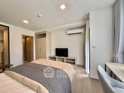 Modern bedroom with cozy bedding, air conditioning, and a sleek TV setup, perfect for relaxation.