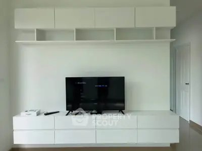 Modern living room with sleek white cabinetry and mounted TV for stylish entertainment setup.