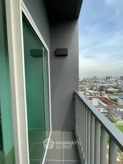 Modern high-rise balcony with stunning city view and sleek glass door.